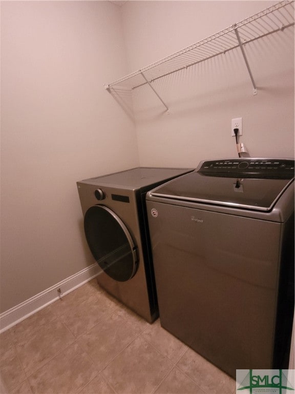 laundry area with light tile patterned flooring and washer and dryer