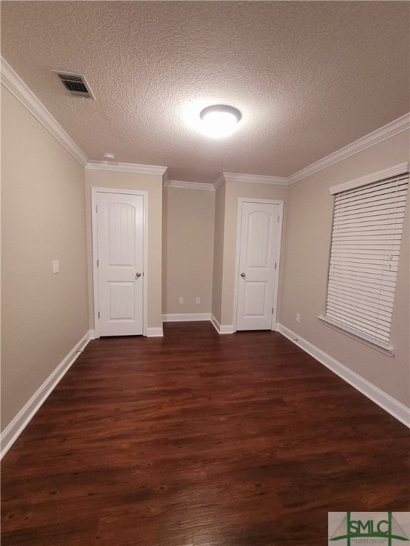 unfurnished bedroom with a textured ceiling, crown molding, and dark hardwood / wood-style floors