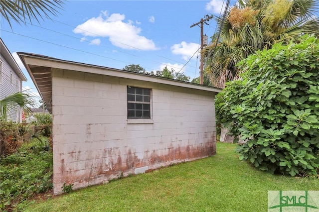 view of side of home with a yard and an outdoor structure