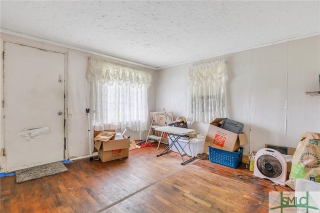 miscellaneous room featuring dark hardwood / wood-style flooring, a textured ceiling, and ornamental molding