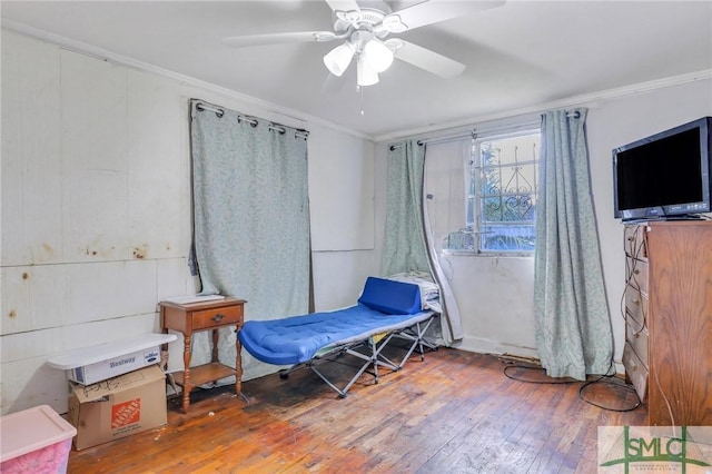 sitting room with wood-type flooring, ceiling fan, and ornamental molding