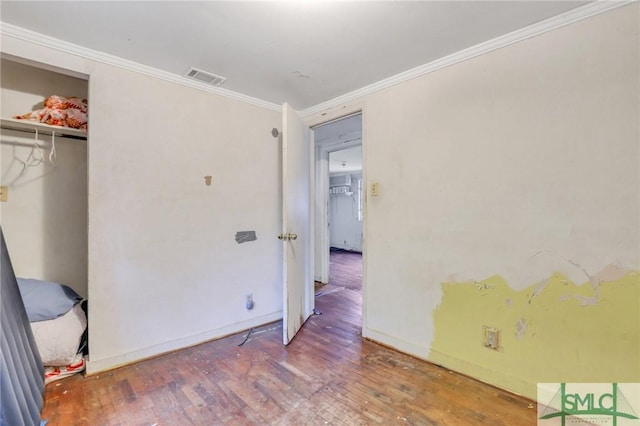 bedroom with a closet, wood-type flooring, and ornamental molding