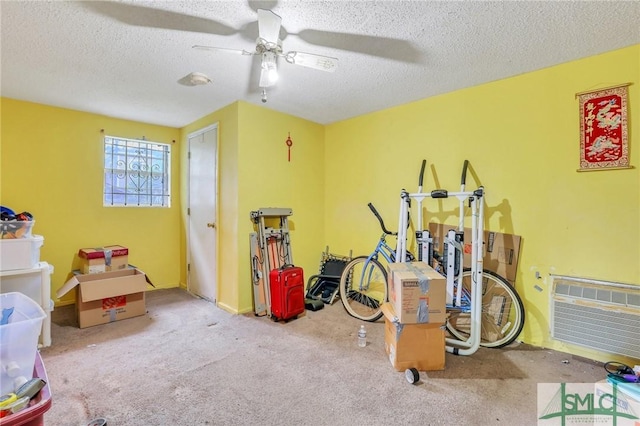 playroom with ceiling fan, light carpet, and a textured ceiling