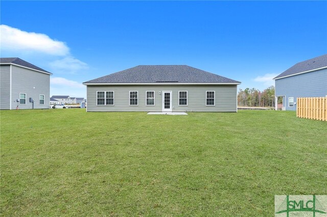 rear view of house with a patio and a yard