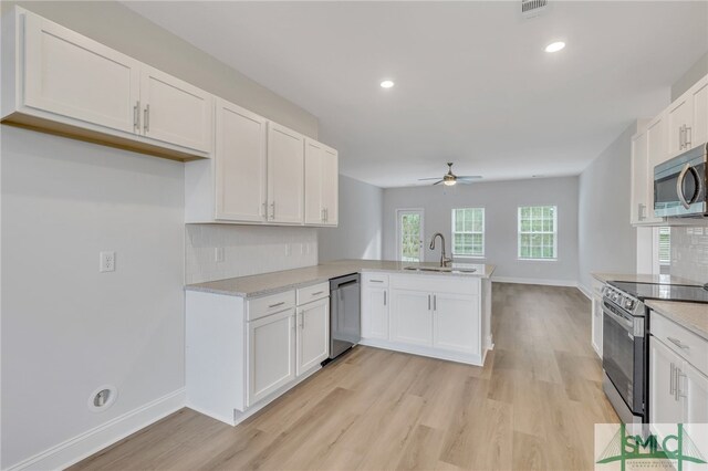 kitchen with white cabinetry, appliances with stainless steel finishes, sink, and kitchen peninsula