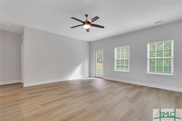 empty room with ceiling fan and light hardwood / wood-style flooring