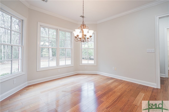 unfurnished dining area featuring ornamental molding, light hardwood / wood-style flooring, and a notable chandelier