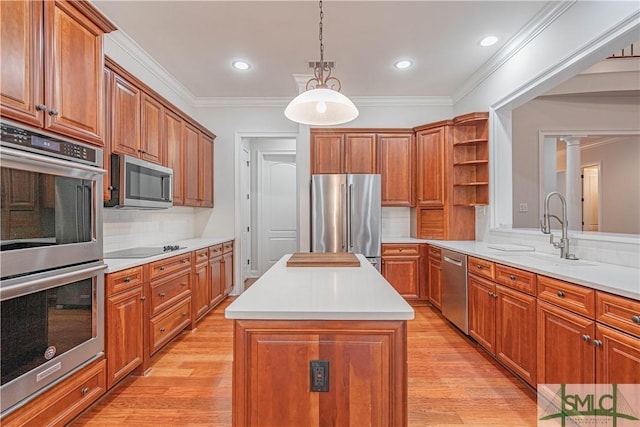 kitchen with tasteful backsplash, stainless steel appliances, sink, decorative light fixtures, and a center island