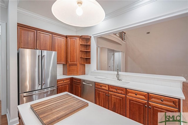 kitchen featuring kitchen peninsula, sink, stainless steel appliances, and ornamental molding