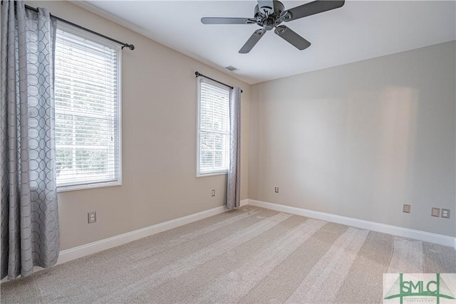 empty room featuring a wealth of natural light, carpet, and ceiling fan