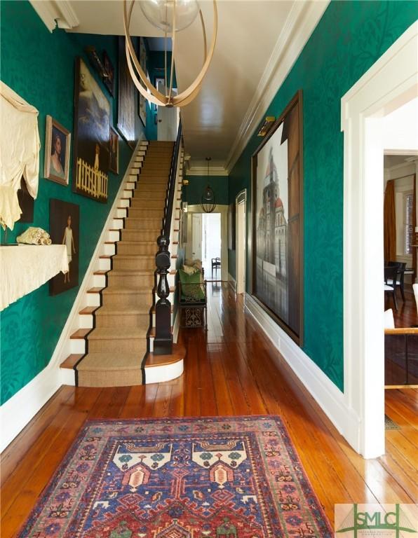 hall featuring wood-type flooring and crown molding