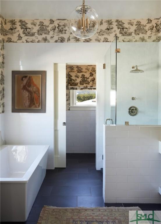 bathroom featuring tile patterned floors, independent shower and bath, and an inviting chandelier