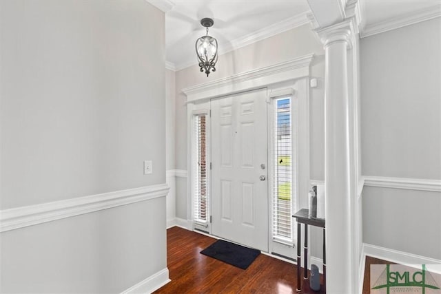 foyer with dark wood-type flooring, ornamental molding, and ornate columns