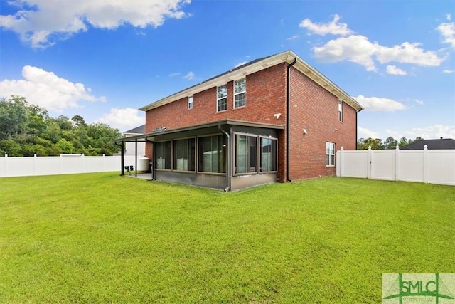 rear view of property with a sunroom and a lawn