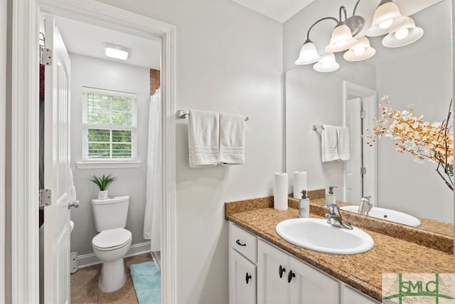 bathroom with toilet, vanity, and tile patterned flooring