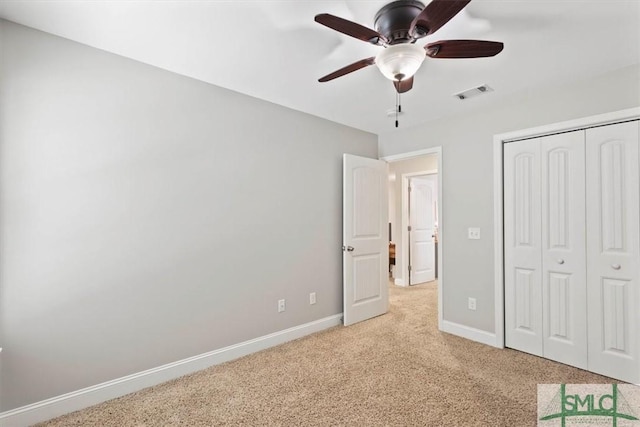 unfurnished bedroom with ceiling fan, light colored carpet, and a closet