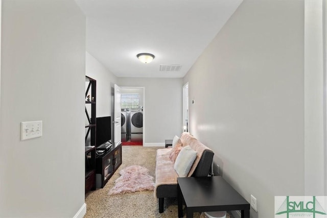 carpeted living room featuring washing machine and clothes dryer