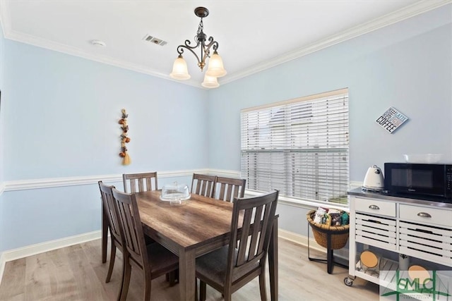 dining area featuring a wealth of natural light, ornamental molding, and light hardwood / wood-style floors