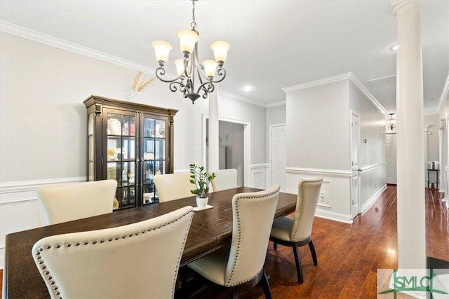 dining room with a chandelier, dark hardwood / wood-style floors, ornamental molding, and ornate columns