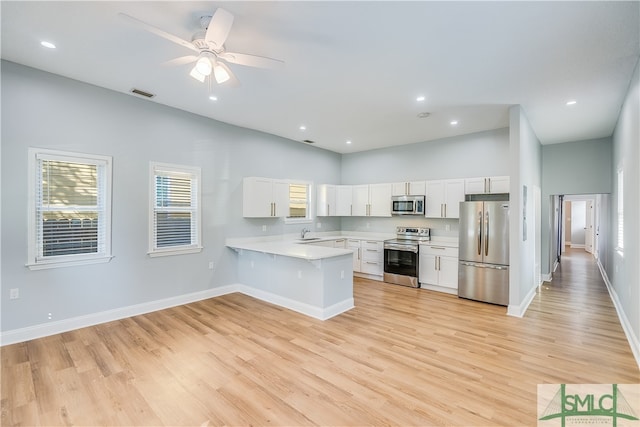 kitchen featuring white cabinetry, light hardwood / wood-style floors, stainless steel appliances, and kitchen peninsula