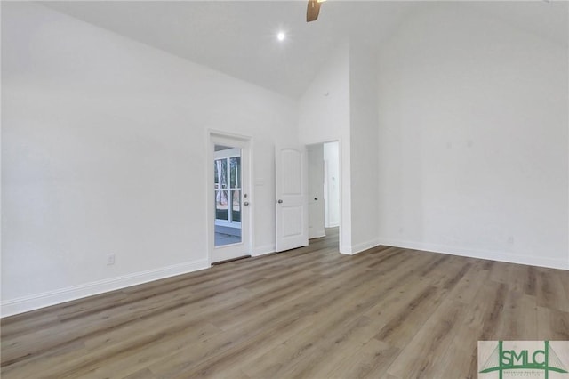 spare room featuring light wood-type flooring, high vaulted ceiling, and ceiling fan