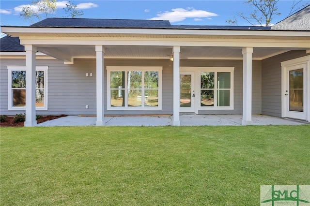 rear view of property with a lawn and a patio area