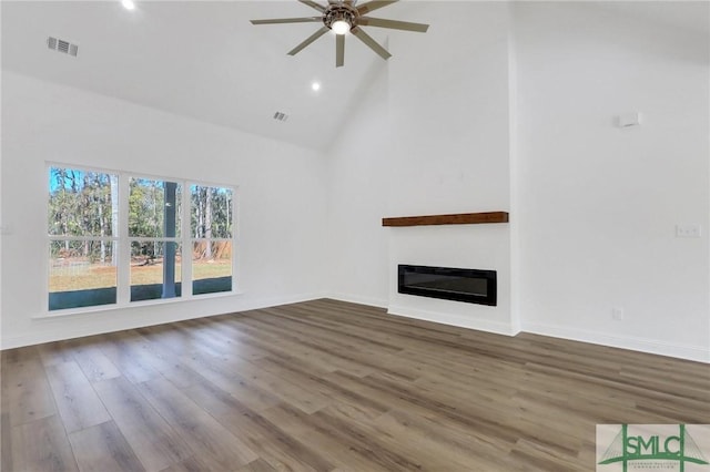 unfurnished living room with hardwood / wood-style floors, ceiling fan, and high vaulted ceiling