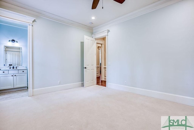 unfurnished bedroom featuring connected bathroom, sink, light colored carpet, ceiling fan, and crown molding