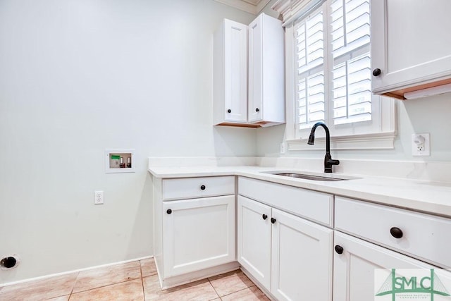 laundry room featuring light tile patterned flooring, cabinets, washer hookup, and sink