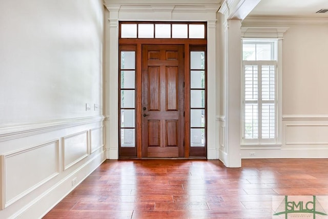 entrance foyer featuring ornamental molding, plenty of natural light, and hardwood / wood-style floors