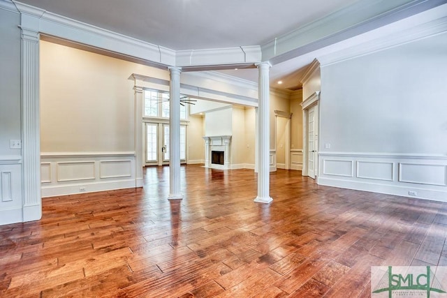 unfurnished room featuring wood-type flooring, ornamental molding, and ornate columns