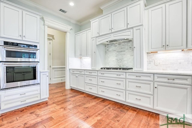 kitchen featuring crown molding, stainless steel appliances, and white cabinets