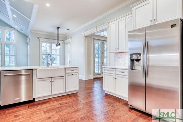 kitchen featuring white cabinetry, stainless steel appliances, sink, and pendant lighting