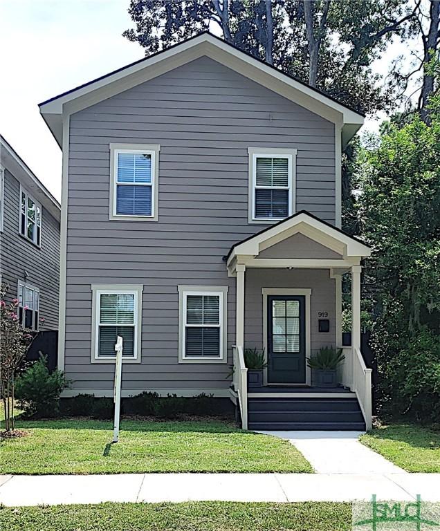 view of front facade with covered porch and a front yard