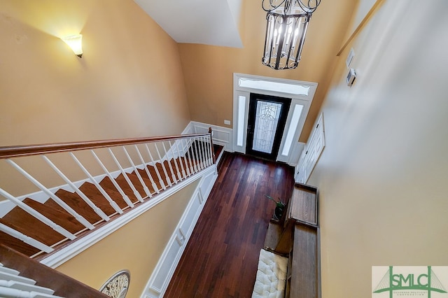 foyer entrance with an inviting chandelier, a high ceiling, and dark hardwood / wood-style floors