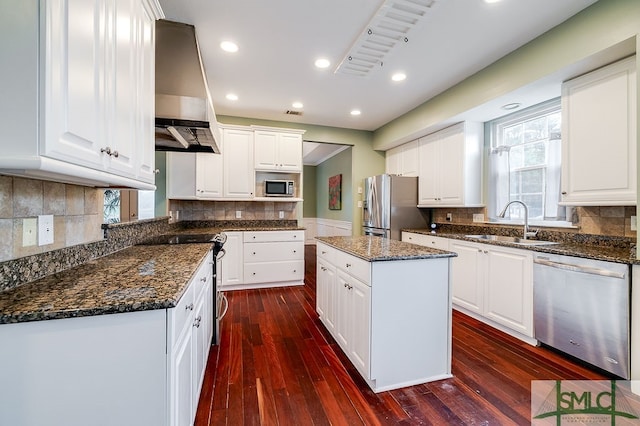 kitchen with stainless steel appliances, white cabinets, a kitchen island, decorative backsplash, and dark hardwood / wood-style flooring