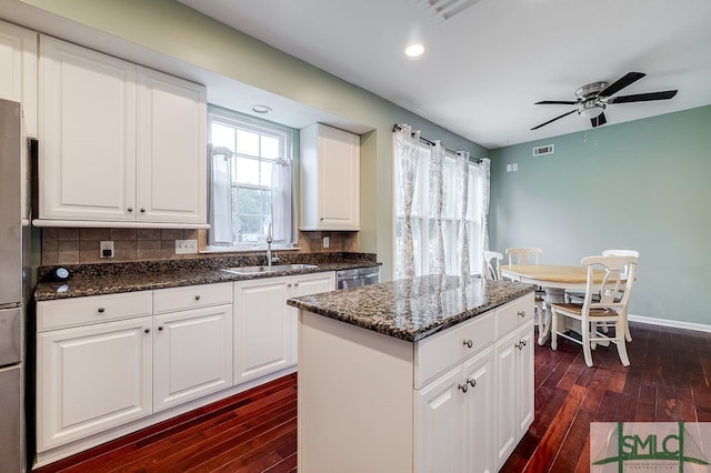 kitchen featuring tasteful backsplash, white cabinets, dark hardwood / wood-style flooring, ceiling fan, and sink