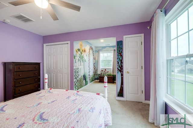 bedroom featuring multiple closets, ceiling fan, and carpet flooring