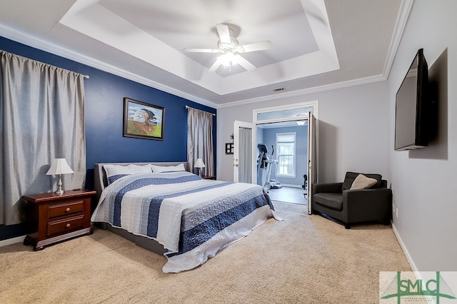 carpeted bedroom featuring ceiling fan, a raised ceiling, and ornamental molding