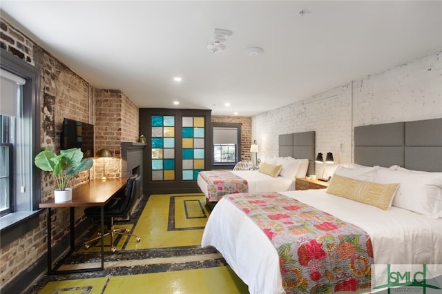 bedroom with multiple windows and brick wall