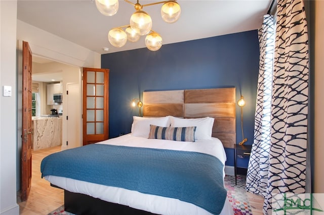 bedroom featuring wood-type flooring and a chandelier