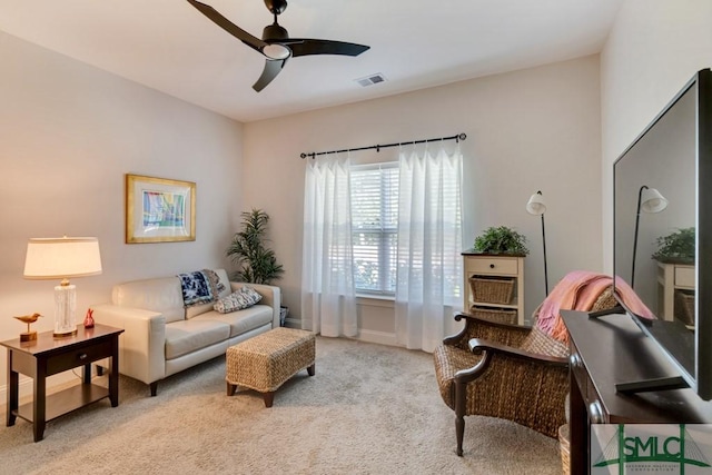 living area featuring light carpet and ceiling fan