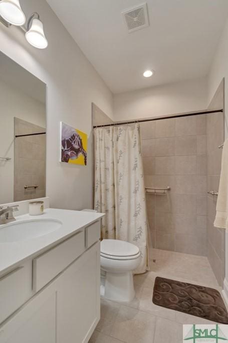 bathroom featuring tile patterned flooring, vanity, toilet, and walk in shower