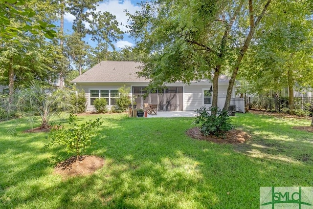 rear view of house featuring a yard and a patio