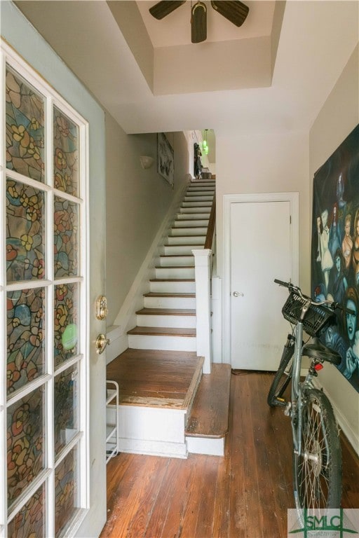 interior space featuring wood-type flooring, ceiling fan, and a tray ceiling