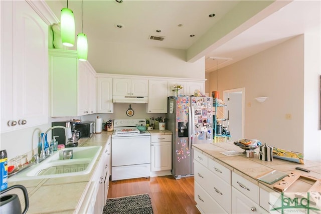 kitchen with stainless steel refrigerator with ice dispenser, sink, hanging light fixtures, tile counters, and white range with electric stovetop