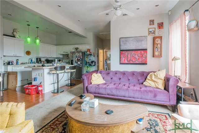 living room featuring ceiling fan and light wood-type flooring