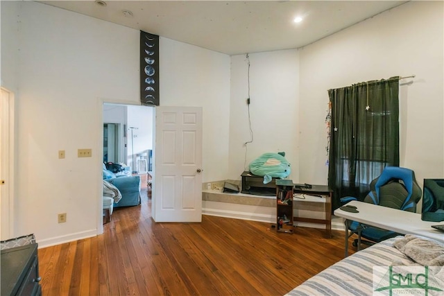 living area featuring a high ceiling and dark wood-type flooring