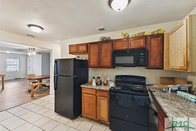 kitchen featuring light stone counters, ceiling fan, black appliances, and light tile patterned floors