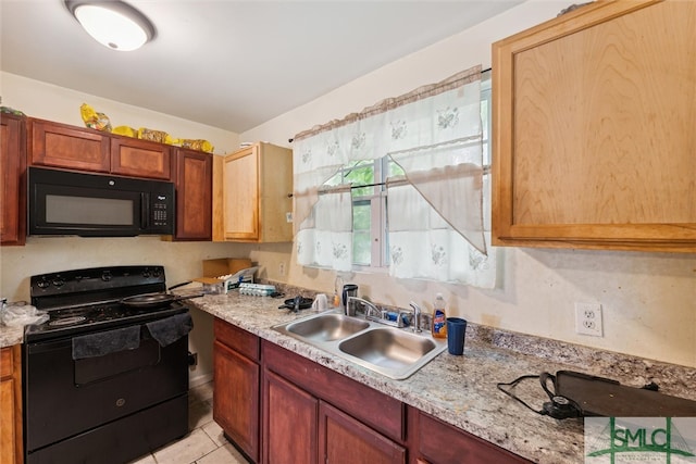 kitchen featuring sink, light stone countertops, black appliances, and light tile patterned floors